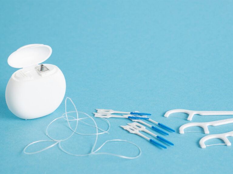 String, pick and interdental flossers on a blue backdrop